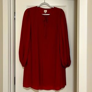 Red long-sleeve pleated a-line dress.